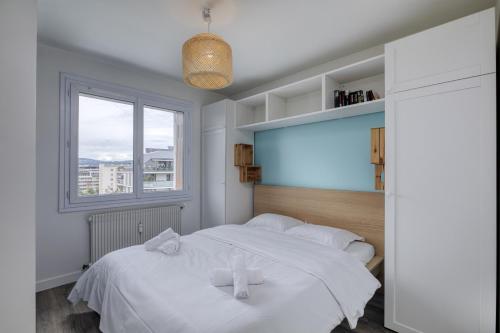 une chambre avec un lit blanc et une fenêtre dans l'établissement Le Central Park, à Annecy