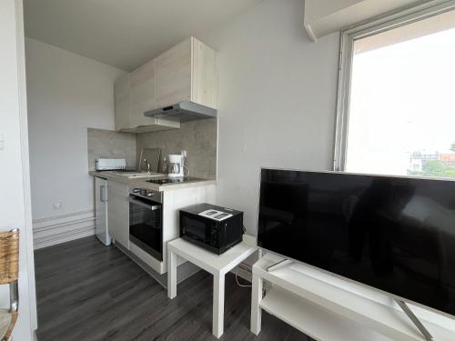 Il comprend une petite cuisine avec une grande télévision à écran plat. dans l'établissement President22B5, à Le Touquet-Paris-Plage