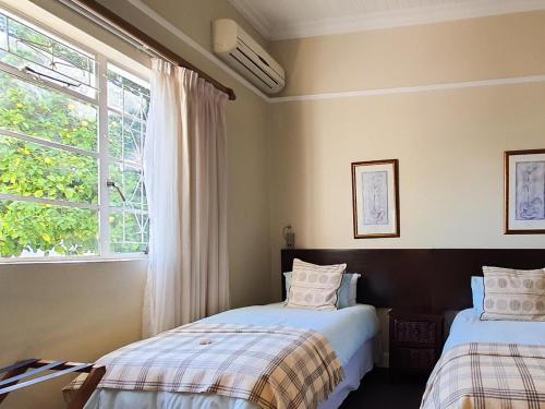 a bedroom with two beds and a window at Cummings Guesthouse in Wellington