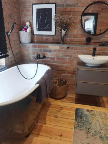 a bathroom with a white tub and a sink at Apartments PSD - Filmowa in Słupsk