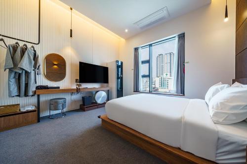 a bedroom with a large white bed and a window at Hotel Haedeun in Sokcho