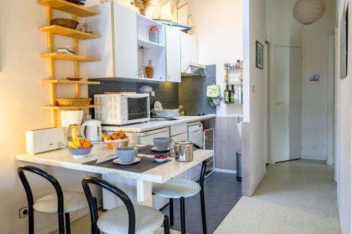 une cuisine avec un comptoir, des chaises et une table dans l'établissement Apartment with 3 windows overlooking the port of St Martin de Ré, à Saint-Martin-de-Ré