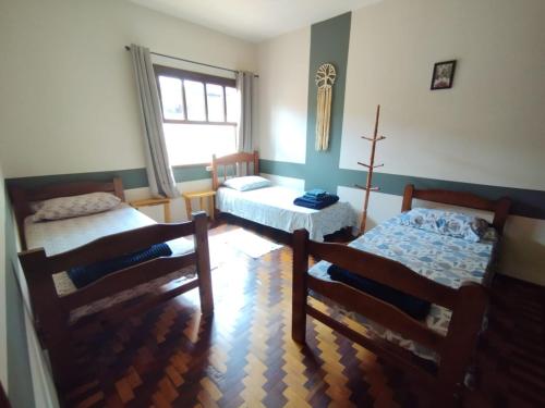 een slaapkamer met 2 bedden en een raam bij Recanto Jacarandá in Ouro Fino