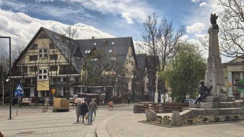 扎科帕内VisitZakopane - Mohito Apartment的一群人走在一座大建筑前面