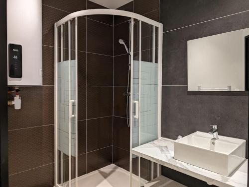 a bathroom with a shower with a sink and a mirror at R'Apparts T3 Industrial Spirit in Grenoble