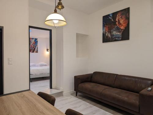 a living room with a brown couch and a mirror at R'Apparts T3 Industrial Spirit in Grenoble