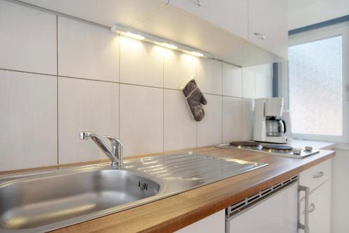 a kitchen with a sink and a coffee maker on a counter at Bungalow Netzboden, Bgl 28 in Dranske
