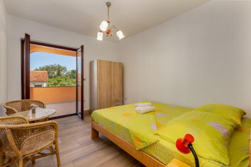 a bedroom with a bed and a table and a balcony at Irena&Dolores Apartments in Malinska