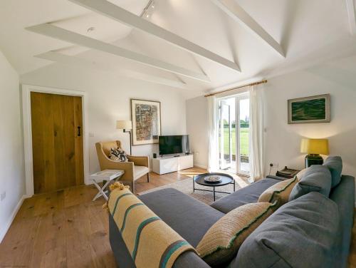 a living room with a couch and a tv at The Stables , Birdham in Birdham