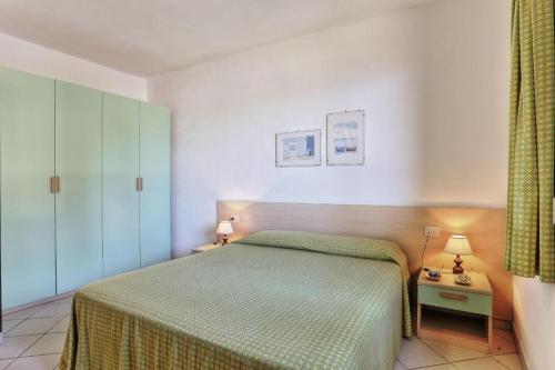 a bedroom with a bed with a green bedspread at Casa Ilva - Colle Paradiso Experience in Capoliveri