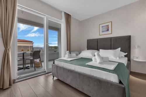 a bedroom with a large bed and a balcony at Villa Olea Prestige in Promajna