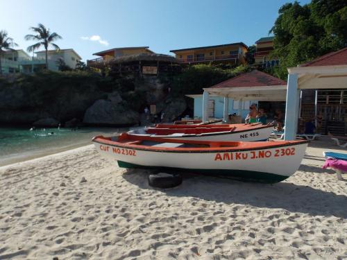 three boats sitting on a beach near the water at Bon Bini Lagun Curacao in Lagun