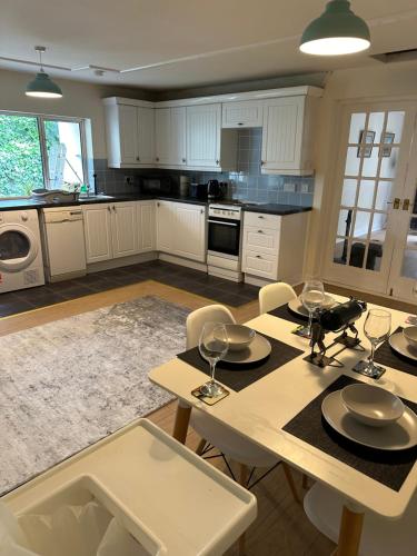 a kitchen with white cabinets and a table and chairs at 1 bed annex with extra sofa bed ideal for families and business guests in Littleport