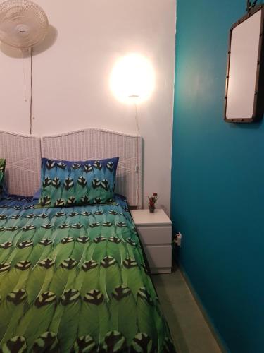 a bedroom with a bed with a green comforter at Bon Bini Lagun Curacao in Lagun