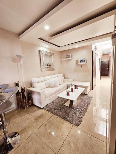 Apartamento SamSay I في كرتاغو: غرفة معيشة مع أريكة بيضاء وطاولة