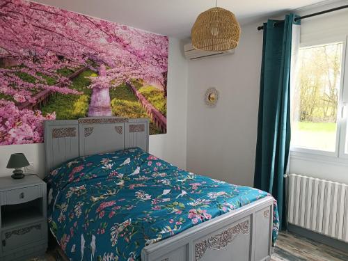 une chambre avec un lit avec un tableau sur le mur dans l'établissement Pleine nature, 10 min zoo Beauval Mareuil sur cher, à Mareuil-sur-Cher