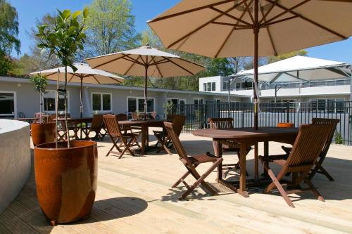 a group of tables and umbrellas on a patio at Anchorage Resort Taupo NZ in Taupo