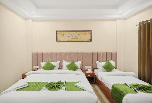 um quarto de hotel com duas camas com almofadas verdes em One Earth Elegant em Rishikesh