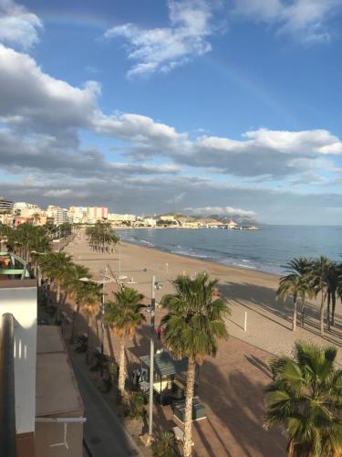 a view of a beach with palm trees and the ocean at Beach apartment-VillaJoyosa, north Alicante in Villajoyosa