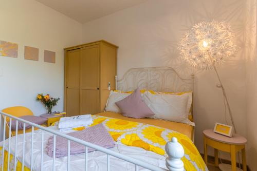 1 dormitorio con cama y lámpara de araña en Casamina vista lago Verbania, en Arizzano