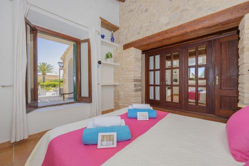 a bedroom with a bed and a large window at Villa Can Cosme in Alcudia