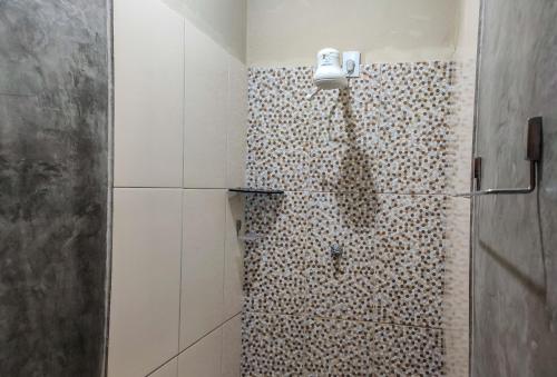 ein Bad mit einer Dusche und einer gefliesten Wand in der Unterkunft Casa Mar Self Jeri in Jericoacoara