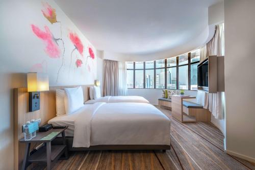 Cette chambre comprend un lit et une grande fenêtre. dans l'établissement Hilton Garden Inn Kuala Lumpur - South, à Kuala Lumpur