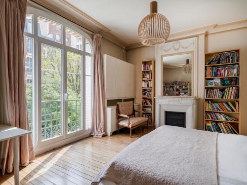 a bedroom with a bed and a fireplace and a window at Paris Mozart Prestige Residence in Paris