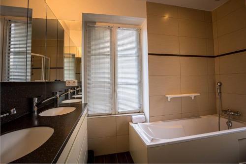 une salle de bain avec deux lavabos et une baignoire dans l'établissement La loge, La Loge House overlooking the sea in Per, à Perros-Guirec