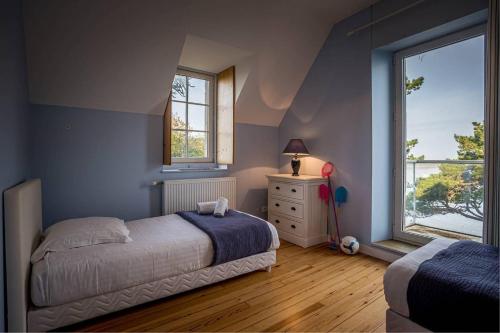 une chambre avec un lit et une fenêtre dans l'établissement La loge, La Loge House overlooking the sea in Per, à Perros-Guirec