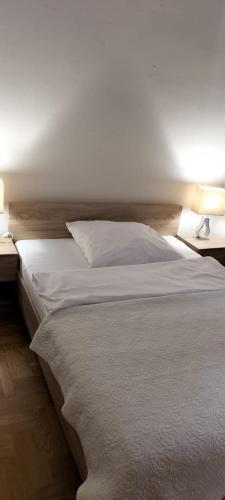 sypialnia z białym łóżkiem i 2 szafkami nocnymi w obiekcie Kamienica w Gdańsku w Gdańsku