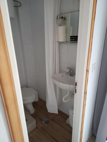 a white bathroom with a toilet and a sink at IOKASTI STUDIO 1 in Andros