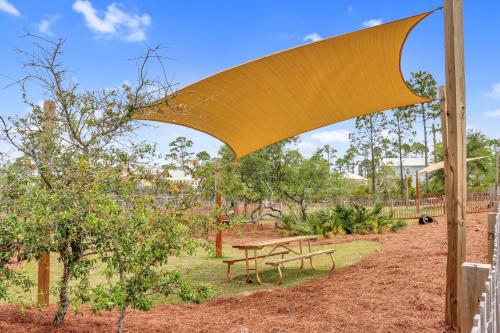 a picnic table and benches in a park at Embreeze Beach Casa by Pristine Properties Vacation Rentals in Highland View
