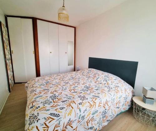 une chambre avec un lit avec une couette dessus dans l'établissement Plage à 50m, charmant T2 dernier étage, à Les Sables-dʼOlonne