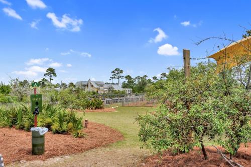 a garden with a fence and some trees and bushes at Embreeze Beach Casa by Pristine Properties Vacation Rentals in Highland View
