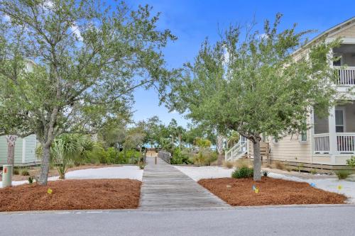 a walkway in front of a house with trees at Embreeze Beach Casa by Pristine Properties Vacation Rentals in Highland View