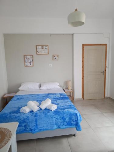 a bedroom with a blue bed with two towels at IOKASTI STUDIO 1 in Andros
