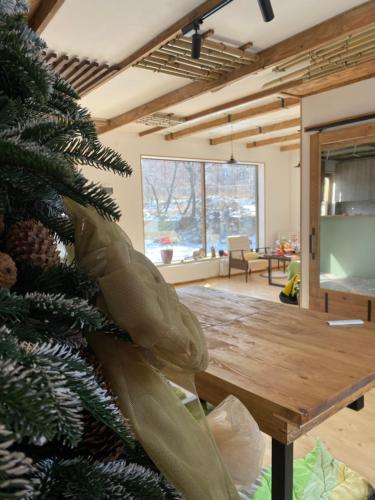a christmas tree in a living room with a wooden table at Eco Art House in Vanadzor