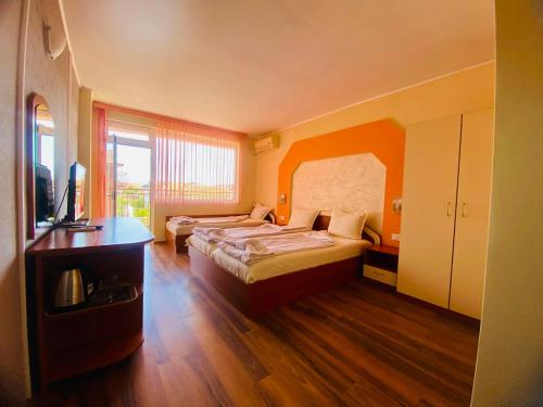 a hotel room with two beds and a television at Guest house Napoli in Ravda