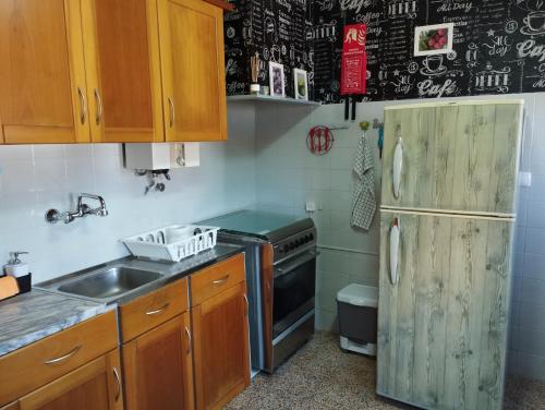 uma cozinha com um frigorífico e um lavatório em Oeste Casa em Vale Covo