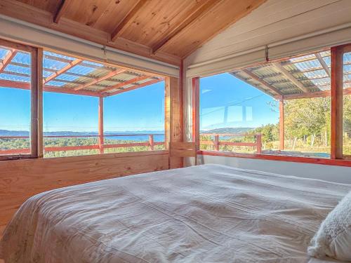 Schlafzimmer mit einem großen Bett und großen Fenstern in der Unterkunft Yatehue Lodge in Chadmo