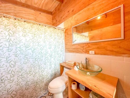 ein Badezimmer mit einem WC, einem Waschbecken und einem Spiegel in der Unterkunft Yatehue Lodge in Chadmo