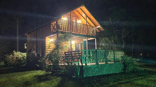 a small house with a porch at night at Pousada Vale da Imbuia chalé para temporada in Urubici