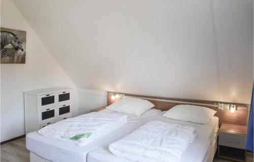 een bed met witte lakens en kussens in een kamer bij Buitengoed Het Lageveld - 51 in Hoge-Hexel