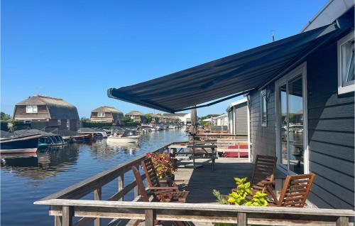 a dock with chairs and tables and boats on the water at Awesome Home In Breukelen in Breukelen