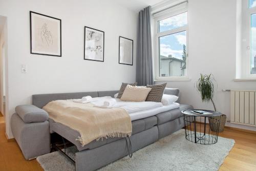 ein Wohnzimmer mit einem Sofa und einem Tisch in der Unterkunft Zeitlos Zuhause Bregenz in Bregenz