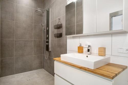 uma casa de banho com um lavatório branco e um chuveiro em Zeitlos Zuhause Bregenz em Bregenz