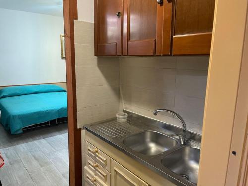 a small kitchen with a sink and a bed at B&B Pineta Mare in Lamezia Terme