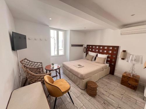 une chambre avec un lit, une table et une télévision dans l'établissement A 2 minutes du port, à Saint-Tropez