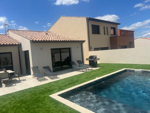 une cour arrière avec une piscine et une maison dans l'établissement Villa Soleada, à Lespignan